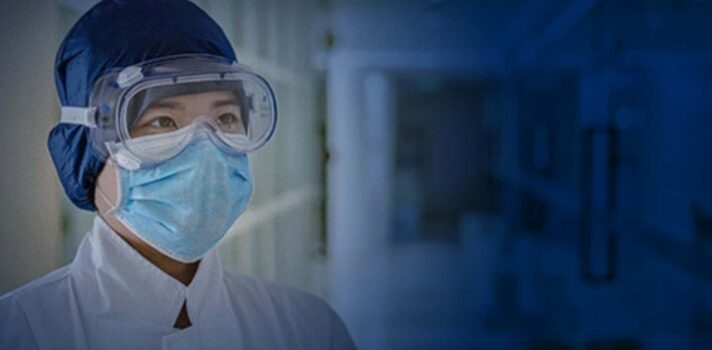 Healthcare worker in safety goggles and mask