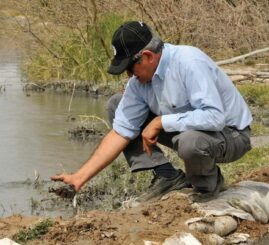 Juan Daniel Pacheco showing polluted water near mine.