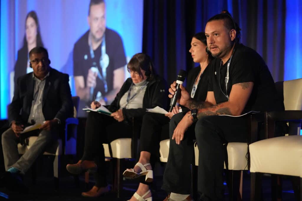 Facilitators on a stage talking at the Justice Conference 2024.