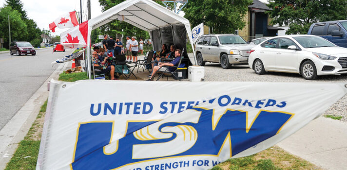 a group of people sitting inside a white tent with white and bleu flag