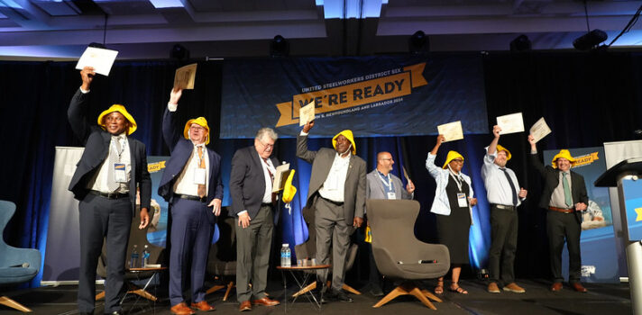 8 people standing on the stage and holding 