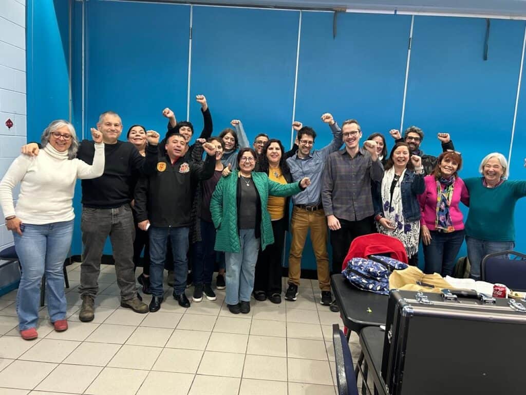 A group of people taking a photo in a room while raising fists.